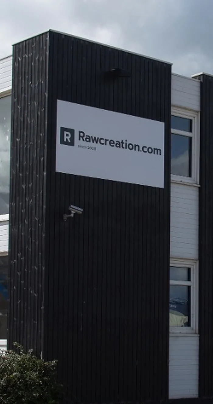 The Rawcreation.com sign on the black-clad corner of the factory building